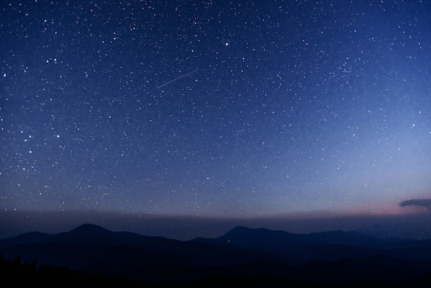 Fantástica lluvia de meteoritos de invierno y las montañas nevadas