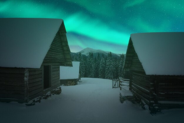 Foto fantástica paisagem de inverno com casas de madeira em montanhas nevadas