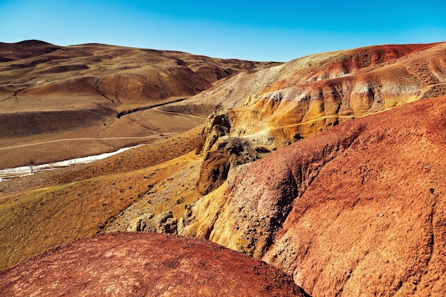 Fantásticas montañas rojas con transiciones de colores brillantes y cielo azul claro en el lugar llamado Mars 1 Altai