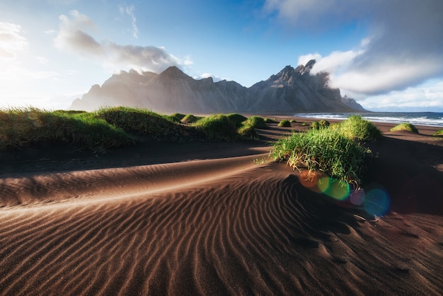 Fantástico al oeste de las montañas y las dunas de arena de lava volcánica en la playa Stokksness, Islandia. Colorido mañana de verano Islandia, Europa