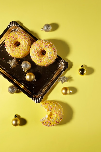 Farbe Donuts auf einem goldenen Tablett und Weihnachtsschmuck