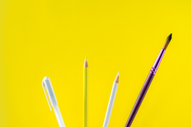 Farbige Bleistifte auf einem gelben Hintergrund mit Platz für Text.