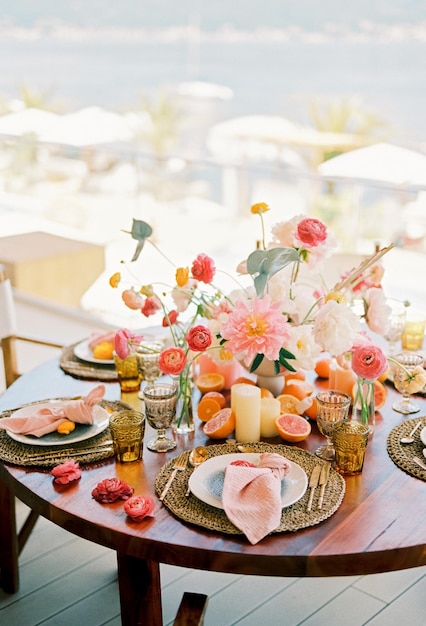 Farbige Blumen auf einem festlichen Tisch mit Orangenhälften und Teller auf Spitzteppichen