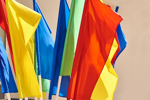 Farbige Flaggen auf Fahnenmasten, die in den Wind fliegen