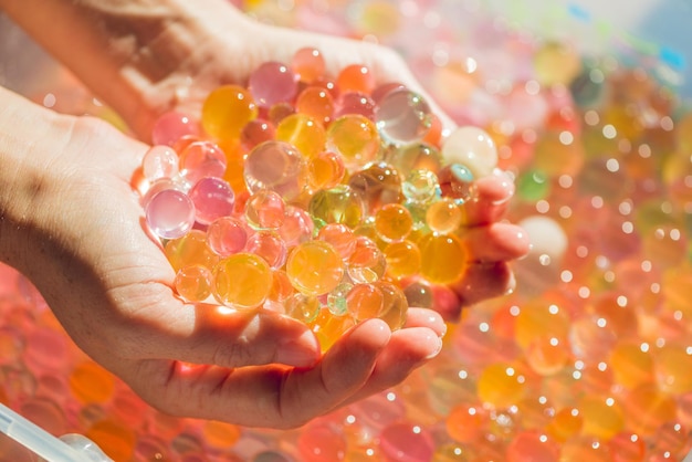 Farbige Kugeln aus Wasserperlen, Hydrogel in den Händen. Sinneserfahrungen.