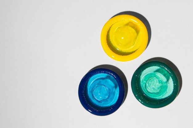 Farbige offene Kondome auf hellgrauem Hintergrund Ansicht von oben