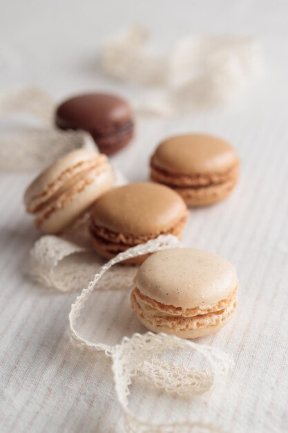 Foto farbige pastellfarbene eco-handgefertigte natürliche makaronen auf weißem hintergrund geschenk für den 8. märz, den internationalen frauentag, den valentinstag vertikalfoto