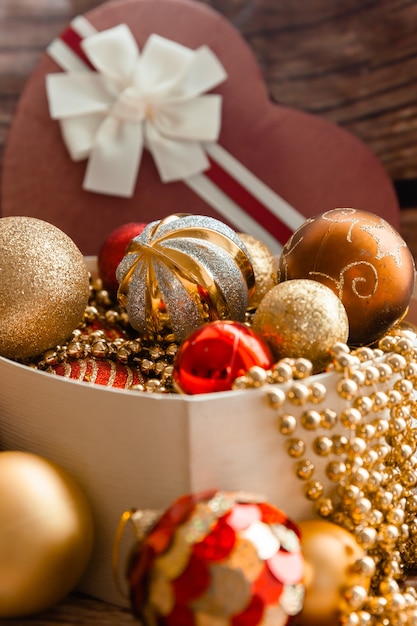 Farbige Weihnachtskugeln in einer Box in Herzform. Weihnachtsdekorationen. Neujahr.