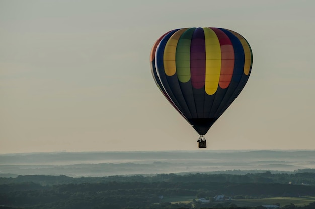 Farbiger Heißluftballon über der Landschaft gegen den Himmel
