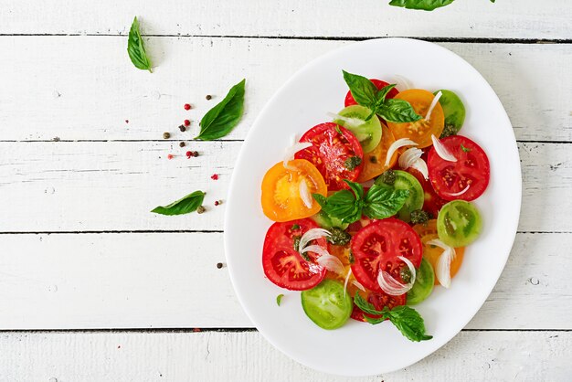 Farbiger Tomatensalat mit Zwiebel und Basilikum Pesto.