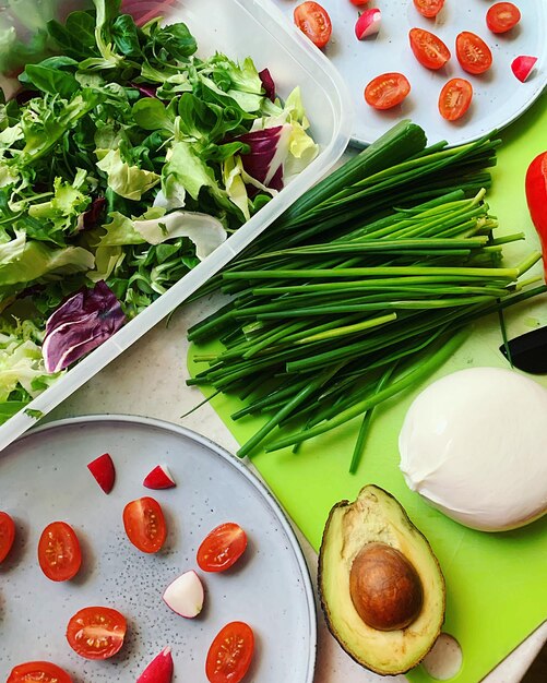 Farbiges Gemüse, Schnitzel, gehackte Tomaten auf einem Teller, frische Burrata, Frühlingsnahrung