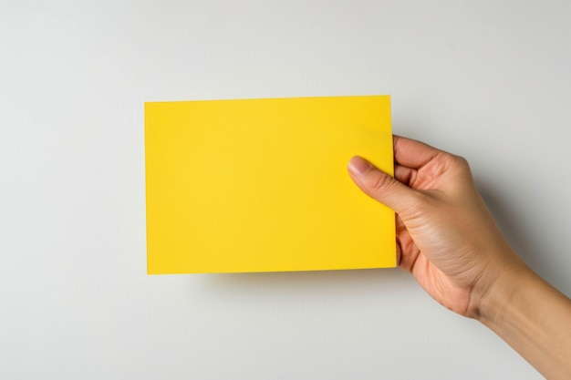 Foto farbiges leerpapier auf weißem hintergrund in der hand