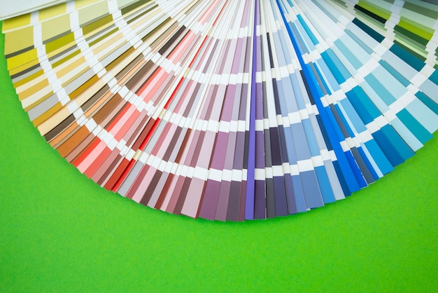 Farbleitfaden close up Sortiment von Blumen für Design Farbpalettenfächer auf grünem Hintergrund Ein Grafikdesigner wählt Farben aus einem Farbpalettenleitfaden aus Farbmusterkatalog