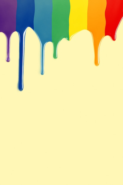 Farbtropfen, die als LGBT-Flagge in gelbem Hintergrund fallen. Regenbogen malen. vertikales Bild mit Kopienraum.