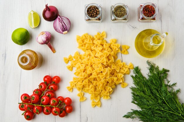 Farfalle crudo con ingredientes sobre una mesa