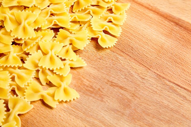 Farfalle italienische Pasta auf hölzernem Buchentisch mit Kopienraum