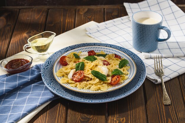 Farfalle con mozzarella de tomates cherry y espinacas al estilo rústico.