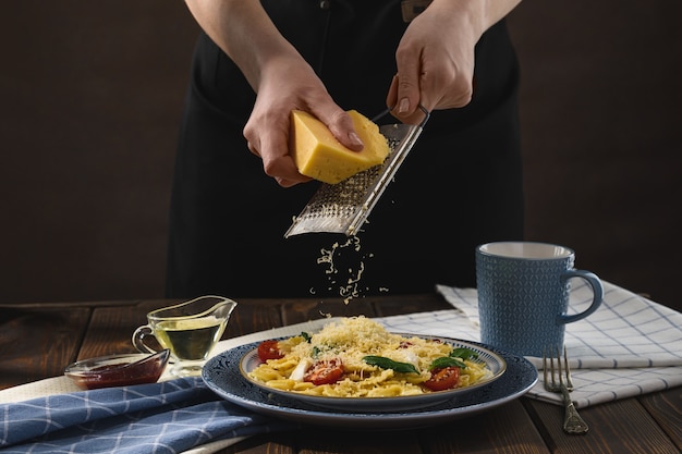 Farfalle con mozzarella de tomates cherry y espinacas al estilo rústico.