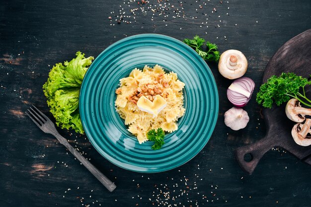 Farfalle-Nudeln mit Brie-Käse und Nüssen Italienische Küche Auf einem hölzernen Hintergrund Ansicht von oben Kopieren Sie Platz