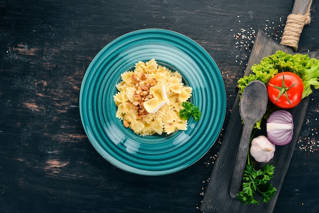 Farfalle-Nudeln mit Brie-Käse und Nüssen Italienische Küche Auf einem hölzernen Hintergrund Ansicht von oben Kopieren Sie Platz