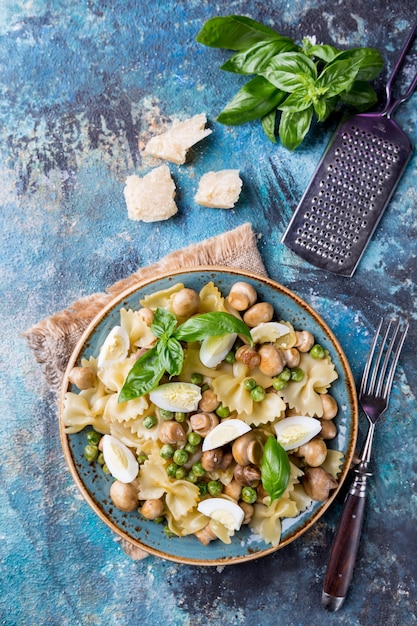 Farfalle Pasta mit Champignons, Erbsen, Ei und Sahnesauce auf einem Teller