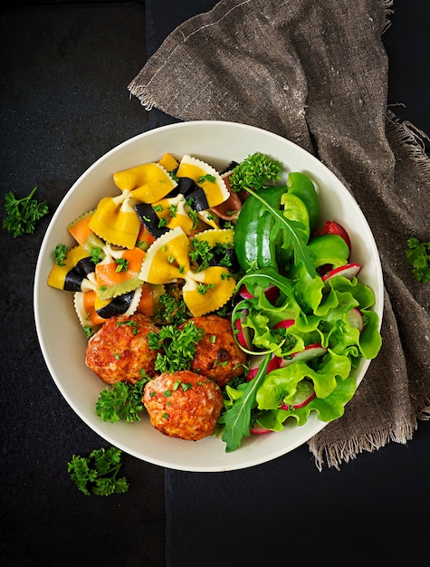 Farfalle pasta de trigo duro con albóndigas horneadas de filete de pollo en salsa de tomate