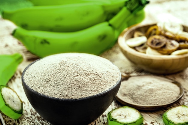 Farinha alternativa, farinha de banana verde caseira, com rodelas de banana frita e batatas fritas ao redor