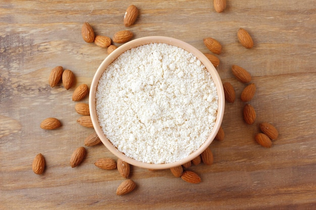 Farinha de amêndoa crua orgânica em tigela sobre mesa de madeira rústica comida sem glúten