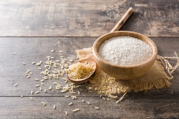 Farinha de arroz branco em uma tigela na mesa de madeira, copie o espaço