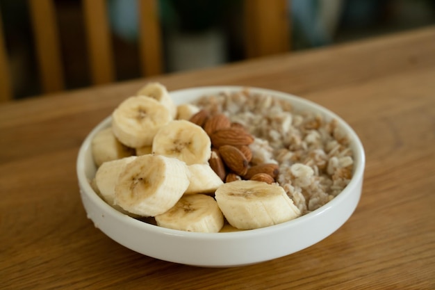 Foto farinha de aveia com mel de banana e amêndoa para o café da manhã em uma mesa