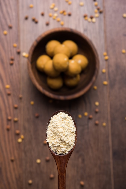 Farinha de grão de bico ou Besan em pó em uma tigela de cerâmica ou madeira junto com doce Laddu ou laddoo