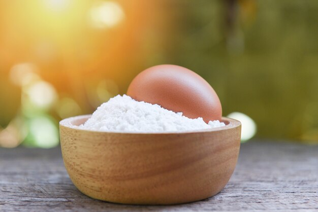 Farinha de pastelaria na natureza tigela de madeira - ovo de farinha caseira cozinhar ingredientes na mesa