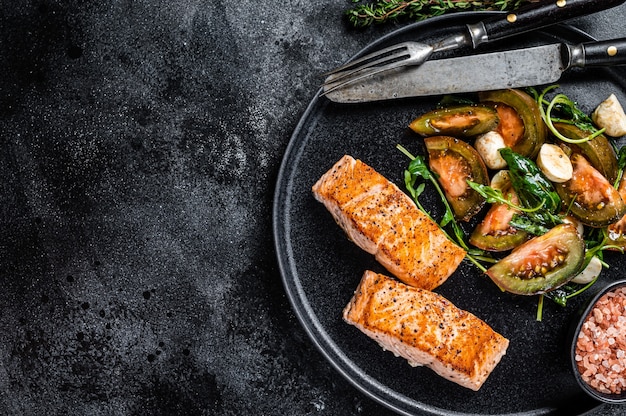 Farinha de peixe com filé de salmão assado e salada de tomate rúcula em um prato