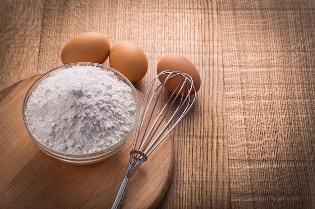 farinha em tigela corolla ovos na placa de madeira, alimentos e bebidas conceito