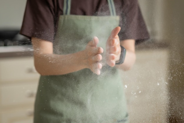 Farinha se espalha em diferentes direções do aplauso nas mãos do cozinheiro Desfoque de movimento e foco suave