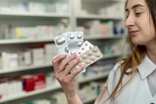 Foto farmacêutica feminina com um pacote de papelão de medicamentos nas mãos no trabalho