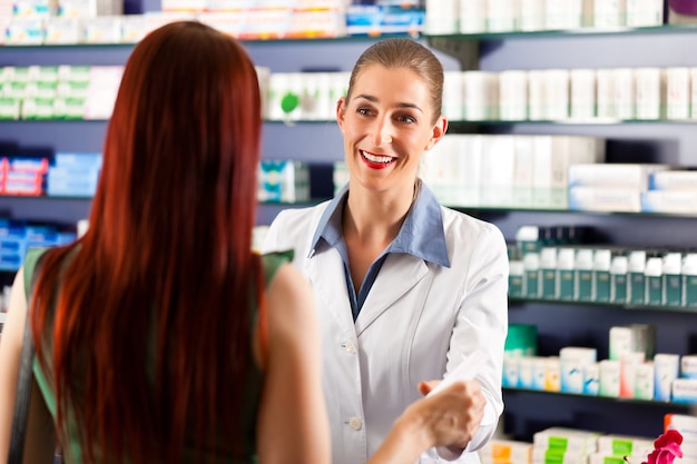 Farmacéutica en su farmacia con un cliente