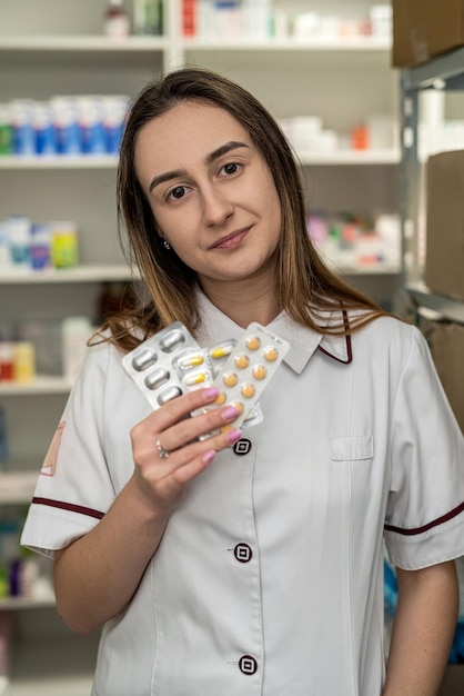 Foto una farmacéutica tiene medicamentos en una farmacia.