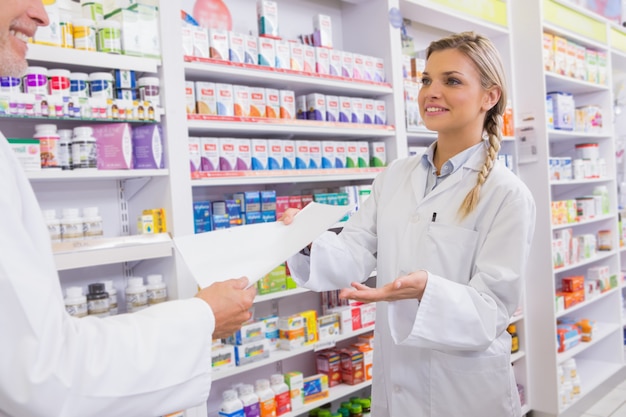 Farmacéutico y aprendiz hablando juntos sobre la medicación