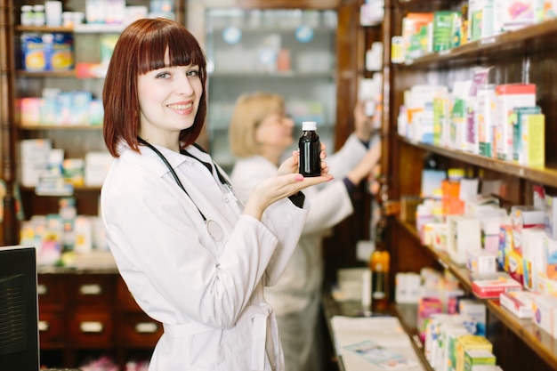Farmacêutico bela dama escolher o produto na farmácia
