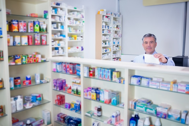 Farmacéutico con cabello gris con una prescripción