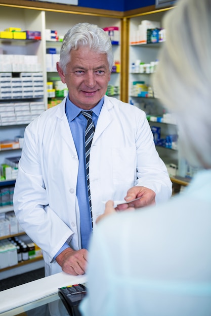 Farmacêutico dando conta ao cliente