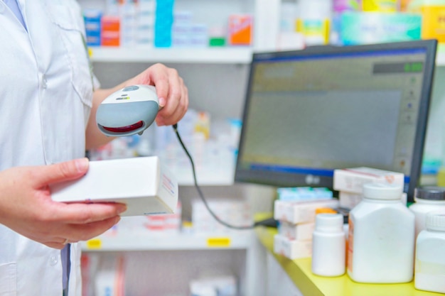 Foto farmacéutico escaneando el código de barras del medicamento en una farmacia farmacia.