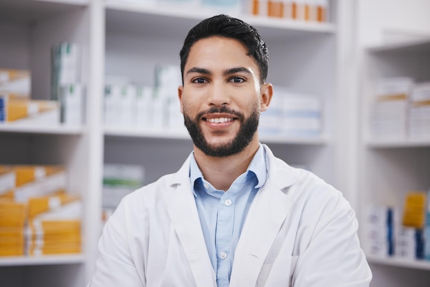 Farmacéutico de farmacia o retrato de un hombre con una sonrisa en una farmacia de atención médica o en una clínica hospitalaria solo Enfréntate al bienestar o a un profesional masculino feliz sonriendo con medicamentos o estantes listos para ayudar