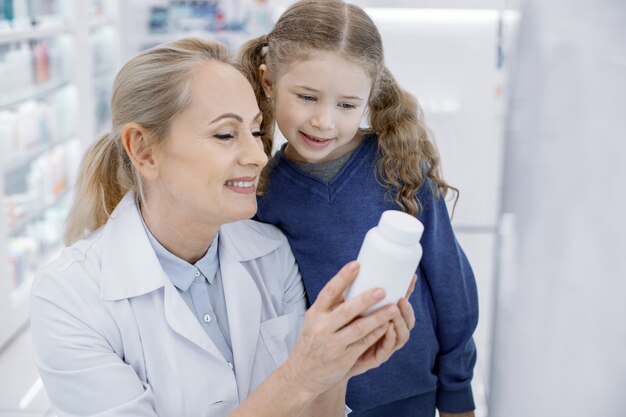 Farmacéutico femenino ayudando a una niña en una farmacia