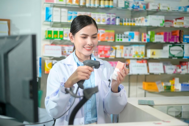 Farmacéutico femenino escaneando código de barras en una caja de medicamentos en una farmacia moderna