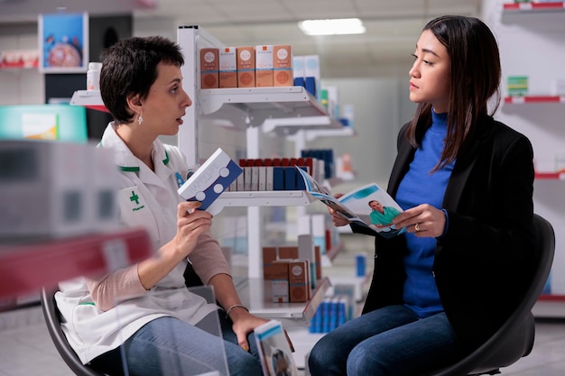 Farmacéutico y joven cliente hablando de vitaminas y salud de la mujer en la farmacia, discutiendo suplementos dietéticos. Empleado de farmacia ayudando al paciente a elegir medicamentos en boticario