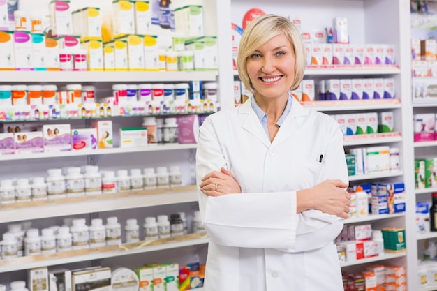 Farmacêutico loiro com os braços cruzados sorrindo para a câmera