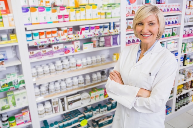 Farmacêutico loiro com os braços cruzados sorrindo para a câmera