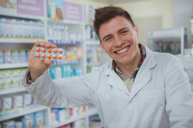 Foto farmacêutico masculino bonito, trabalhando em sua farmácia